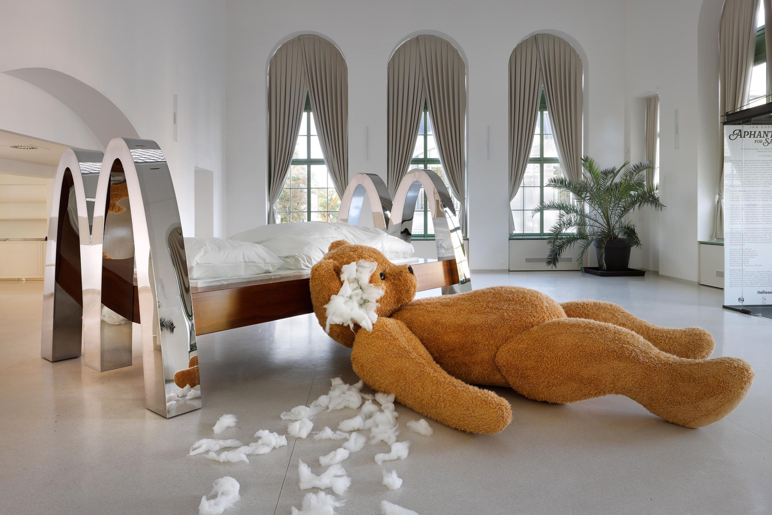 McBed and the teddy bear from the side, cotton stuffing scattered across the floor