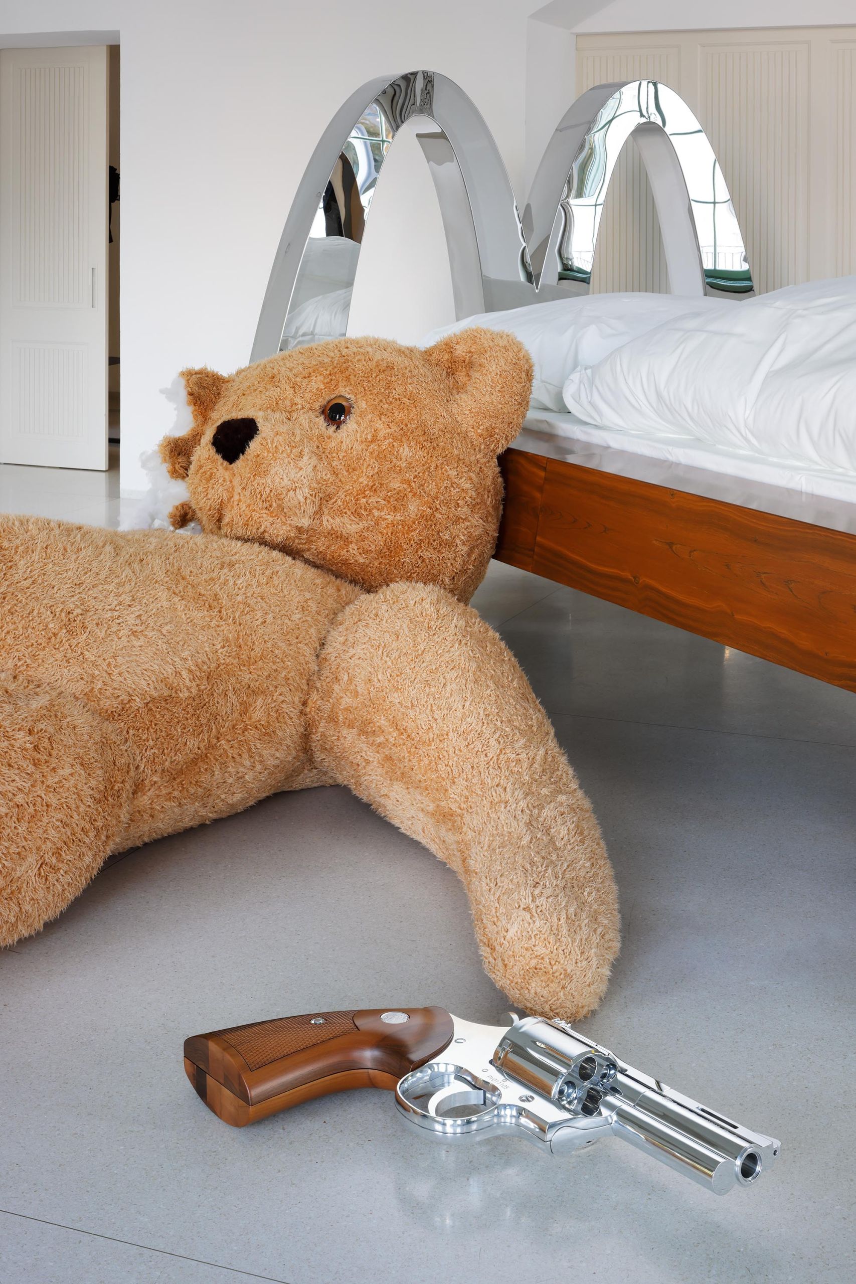 The teddy bear slumped against McBed, the revolver at its side